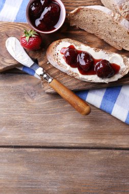 ahşap arka plan üzerinde ev yapımı tereyağı ve çilek reçel taze tost