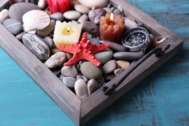 vintage tepsi Denizi çakıl taşları ile deniz yıldızı ve deniz kabukları ahşap zemin üzerine mum