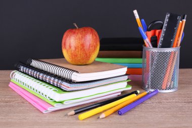 tablodaki koyu arka plan üzerinde okul malzemeleri