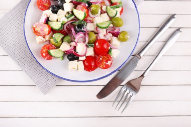 Yunan salatası peçete ahşap zemin üzerinde bir tabakta servis