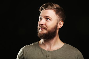 Siyah arka plan üzerine sakallı yakışıklı adam portresi