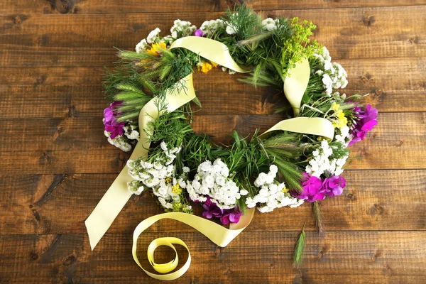 Grinalda de flores silvestres em fundo de madeira — Fotografia de Stock