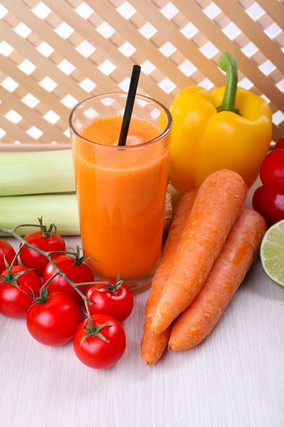 Glass of fresh carrot juice and vegetables on wooden table — Stock Photo, Image