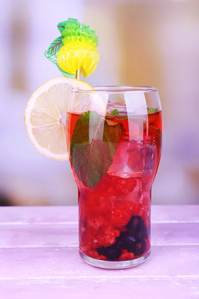 Glasses of cold berry cocktail with lemon on wooden table — Stock Photo, Image