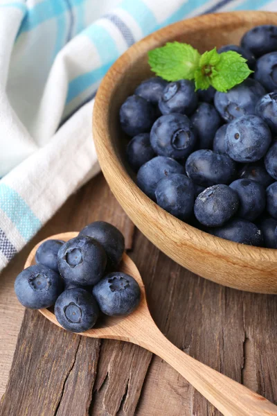 Hölzerne Schale mit Blaubeeren auf Serviette auf Holzgrund Nahaufnahme — Stockfoto