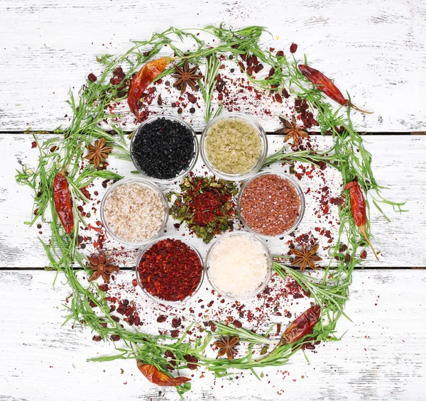 Spices in glass round bowls with herbs and chilly pepper on wooden background — Stock Photo, Image