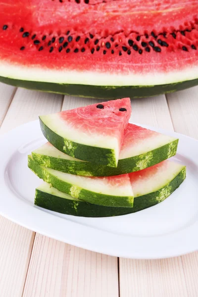 Scheiben Wassermelone auf Teller auf Holzgrund — Stockfoto