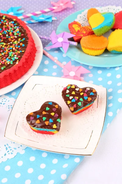 Delicious rainbow cakes on plates, on color wooden background — Stock Photo, Image