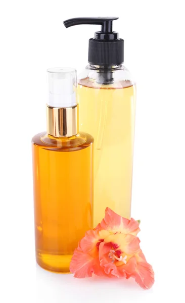Mooie cosmetische flessen en bloem, geïsoleerd op wit — Stockfoto