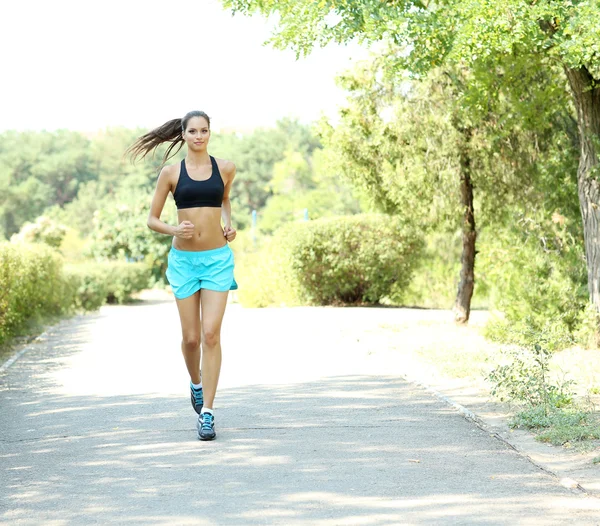 Junge Frau joggt im Park — Stockfoto