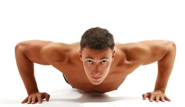 Bonito jovem desportista muscular executar exercício isolado em branco — Fotografia de Stock