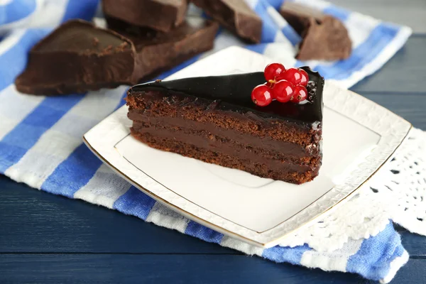 Pastel de chocolate con bayas frescas en el plato, sobre fondo de madera de color — Foto de Stock