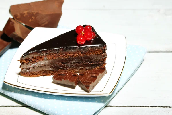 Pastel de chocolate con bayas frescas en el plato, sobre fondo de madera de color — Foto de Stock