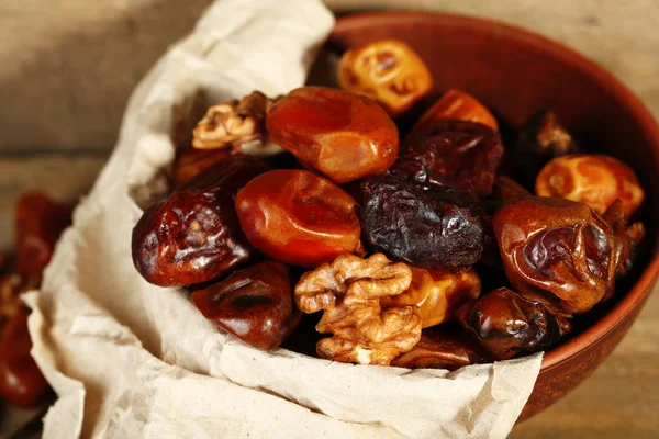 Tasty dates fruits in bowl, on wooden background — Stock Photo, Image