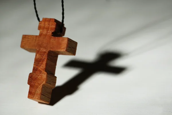 Croce in legno con ombra profonda su sfondo in legno — Foto Stock