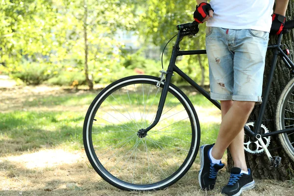 Young man riding bike in city park — Stock Photo, Image