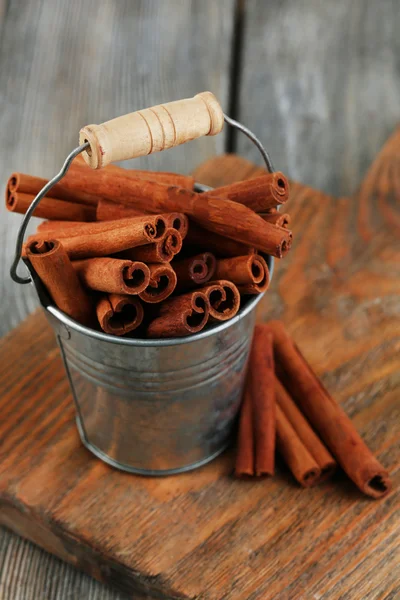 Corteza de canela en un cubo en tabla de madera — Stok fotoğraf