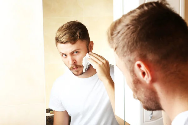 Молодой человек бреется — стоковое фото