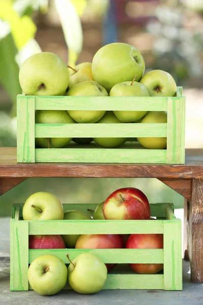 Saftige Äpfel in Holzkisten, im Freien — Stockfoto