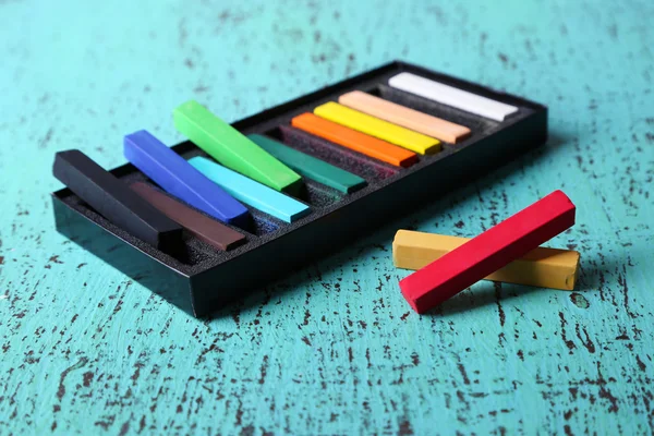 Pasteles de tiza de colores en caja sobre fondo de madera de color —  Fotos de Stock