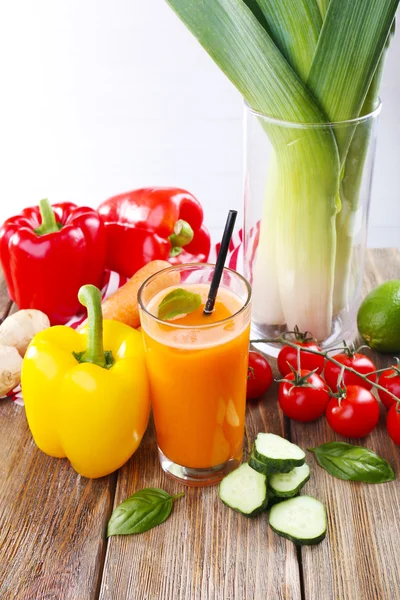 Copo de suco de cenoura fresca e legumes na mesa de madeira — Fotografia de Stock