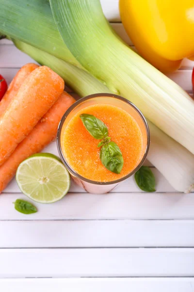 Vaso de jugo de zanahoria fresca y verduras sobre fondo de madera — Foto de Stock