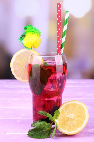 Glass of cold berry cocktail with lemon on wooden table — Stock Photo, Image