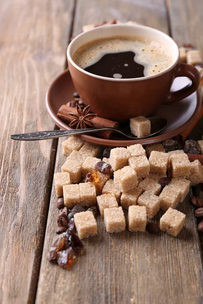 Sucre brun, épices et tasse de café sur fond de bois — Photo