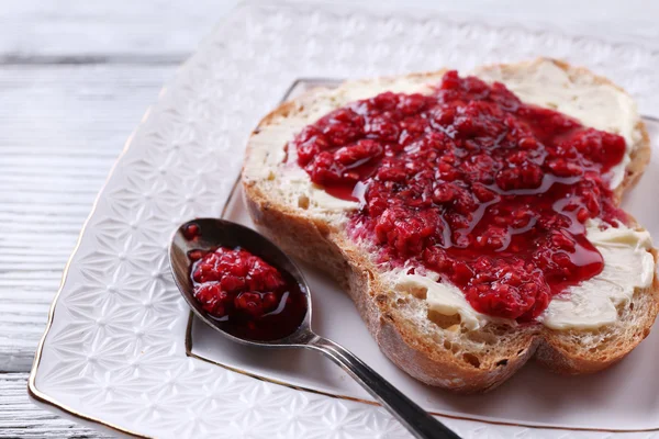 Fresh toast with  homemade butter and raspberry jam on plate on wooden background — Stock Photo, Image