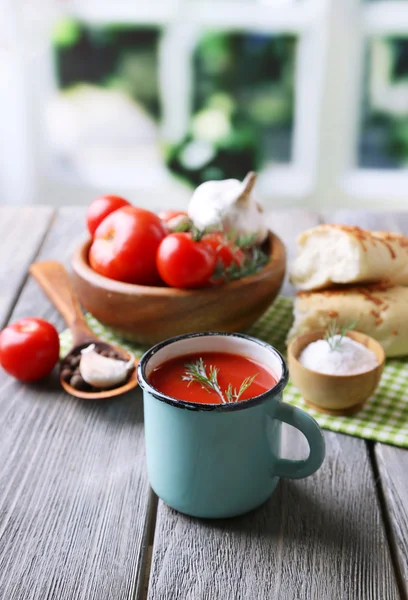 Домашний томатный сок в цветной кружке, хлебные палочки, специи и свежие помидоры на деревянном столе, на ярком — стоковое фото