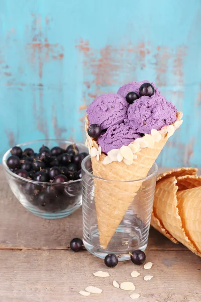 青い木の背景にワッフルコーンの果実とおいしいアイスクリーム — ストック写真