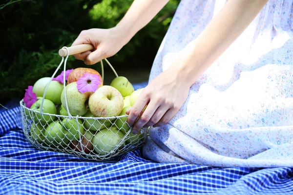 Flicka med korg med äpplen utomhus — Stockfoto