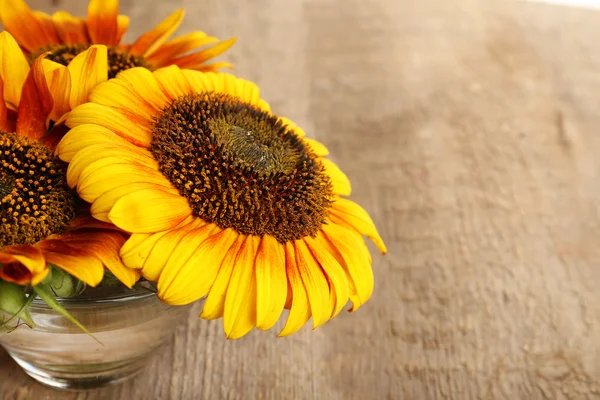 Schöne Sonnenblumen in der Vase auf Holzgrund — Stockfoto