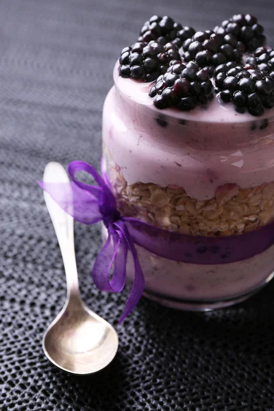 Healthy breakfast - yogurt with  blackberries and muesli served in glass jar, on dark wooden background — Stock Photo, Image