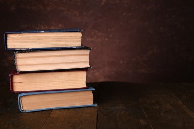 koyu arka plan üzerinde ahşap masa üzerine kitaplar