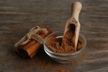 Tarçın kabuğu ve ahşap masa üzerinde toz tarçın