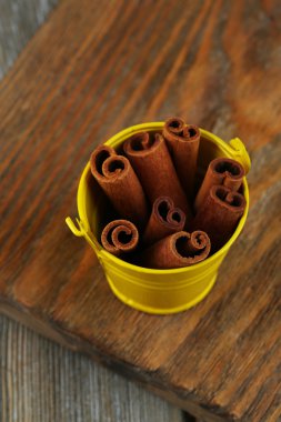 corteza de canela en un cubo en tabla de madera