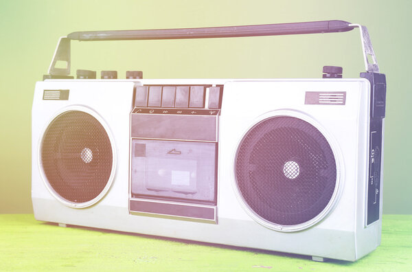 Retro cassette stereo recorder on table on green background