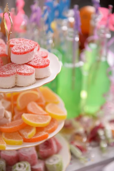 Doces e garrafas de bebida com palha de perto — Fotografia de Stock