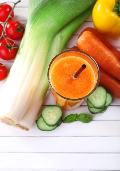 Glas färsk morotsjuice och grönsaker på trä bakgrund — Stockfoto