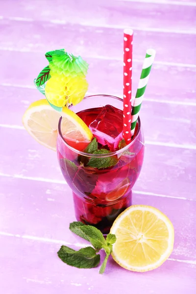 Glass of cold berry cocktail with lemon on wooden background — Stock Photo, Image