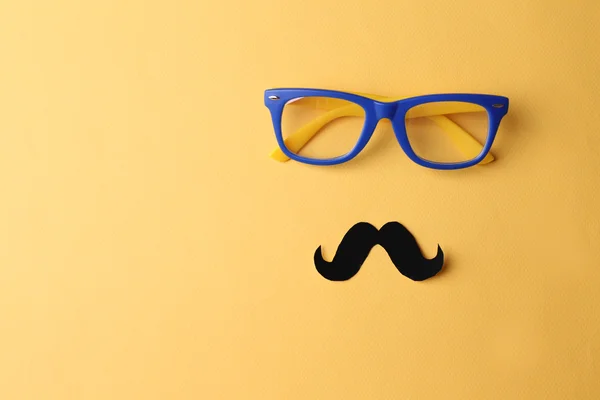 Glasses and mustache forming man face on yellow background — Stock Photo, Image