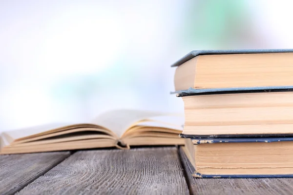 Boeken over houten tafel op natuurlijke achtergrond — Stockfoto