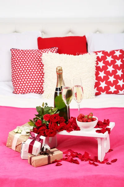Romantisches Stillleben mit Champagner, Erdbeere und Rosen auf dem Bett — Stockfoto