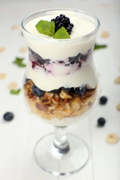 Natuurlijke yoghurt met verse bessen op houten tafel — Stockfoto
