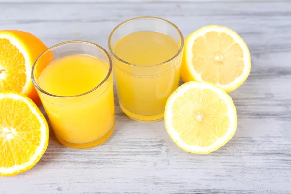 Glas juice med färsk frukt på grå träbord — Stockfoto