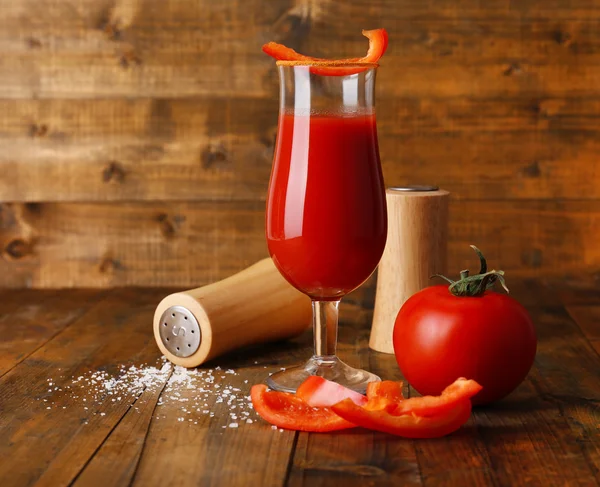 Vaso de sabroso jugo de tomate y pimienta en la mesa de madera — Foto de Stock