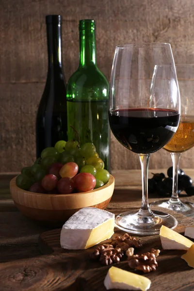 Hermoso bodegón con vino, queso y uva madura sobre fondo de madera —  Fotos de Stock