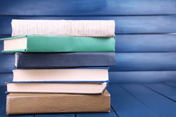 Boeken over donker blauwe houten achtergrond — Stockfoto