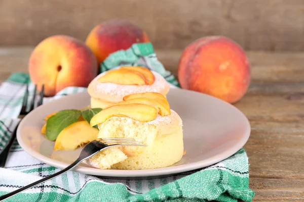 Вкусные мини-торты со свежим персиком, на деревянном столе — стоковое фото